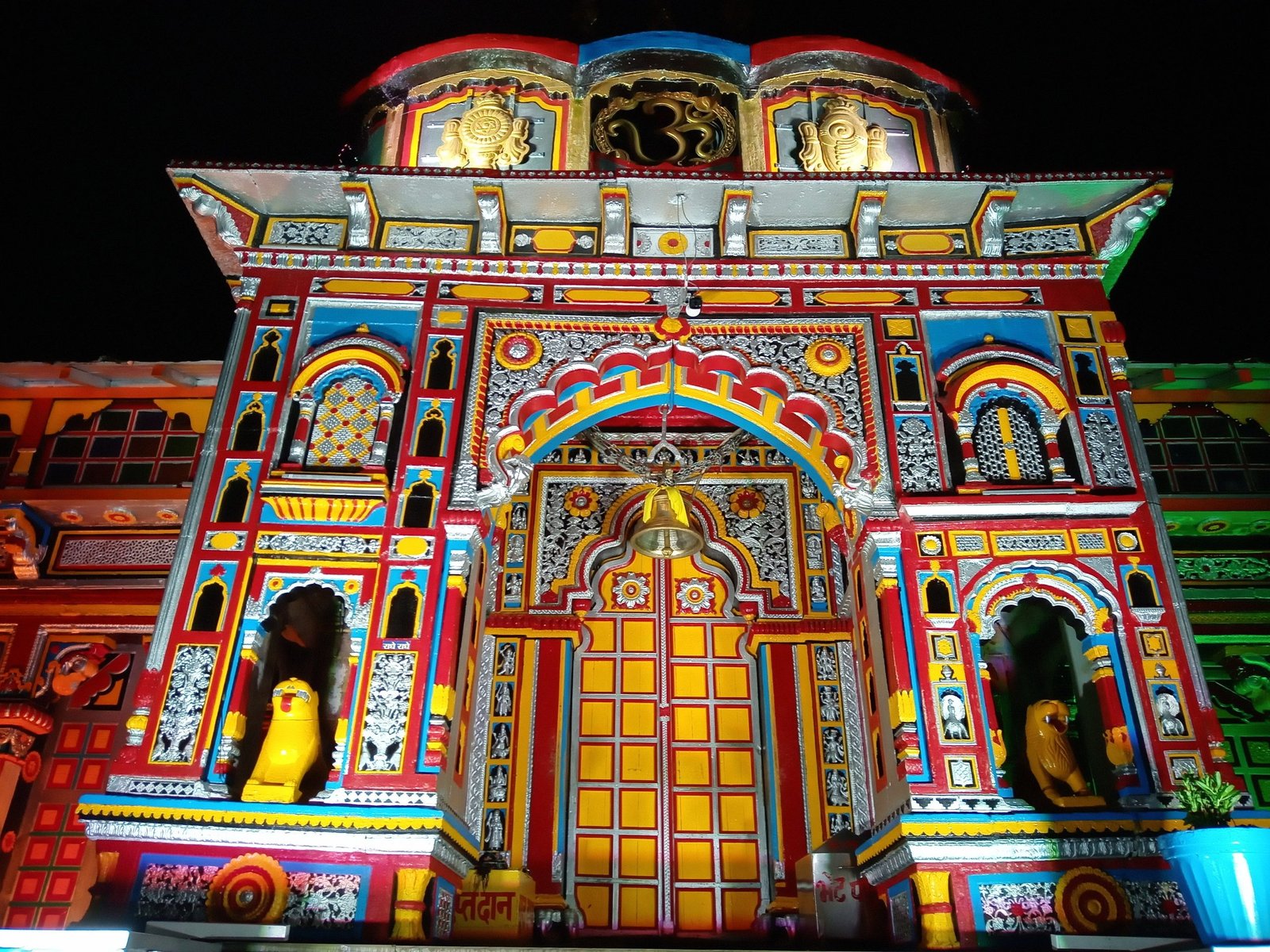 Close-up view of Badrinath Temple's colourful entrance gate covered in snow