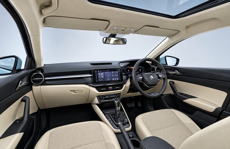 Beige and black dashboard with touchscreen, digital cluster and automatic gear lever inside the car