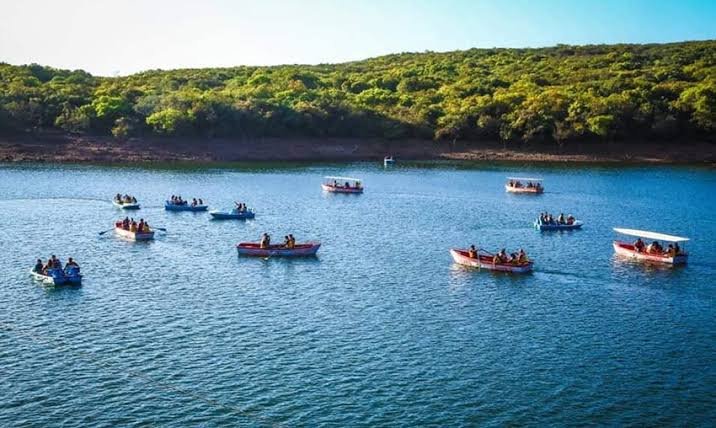 Boats on Venna Lake in Mahabaleshwar with green hills behind
